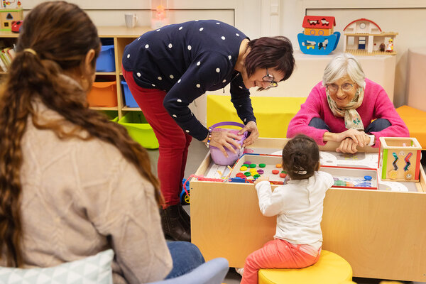 Bénévoles jouant avec une petite fille
