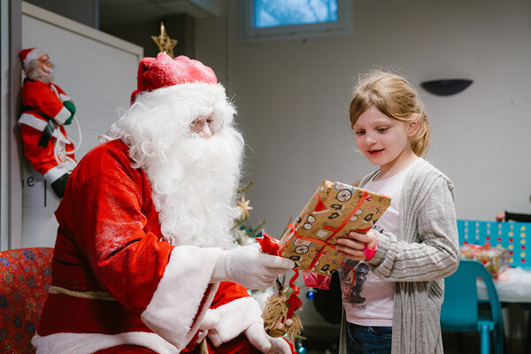 Un Père Noël remet un cadeau à une jeune fille
