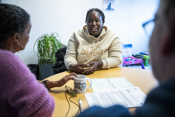 une femme écoutée par des bénévoles lors d'une permanence du Secours Catholique