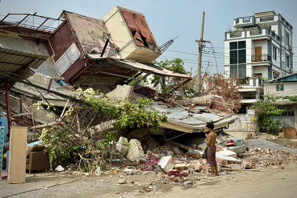 un jeune birman devant des bâtiments effondrés