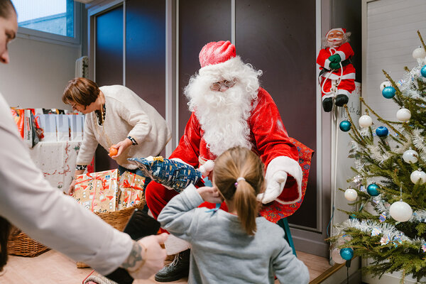un Père Noël distribuant un cadeau à une petite fille