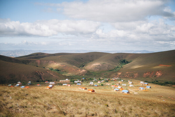 Au fond d’une vallée apparaissent enfin les toits de tôle bleu, vert, rouge ou argenté de maisons dispersées.