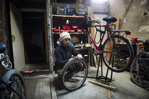 Yacine Babchia, bénévole, s'occupent des vélos. Ceux qui sont trop abîmés, trop chers à réparer, il les démonte pour utiliser les pièces.