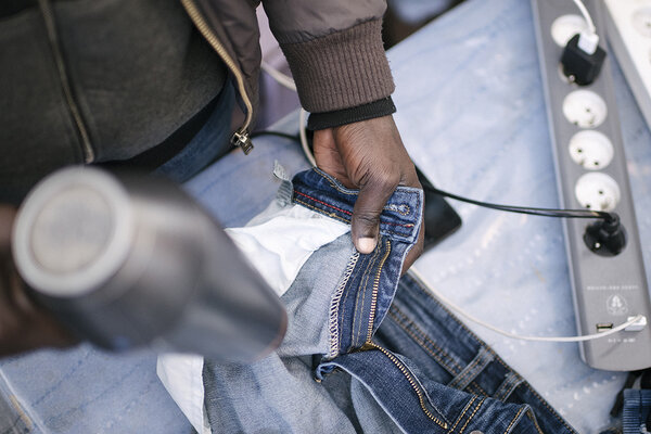 En attendant l'installation de machines à laver, les hommes lavent leurs vêtements à la main, mais le temps est trop humide pour qu'ils sèchent.