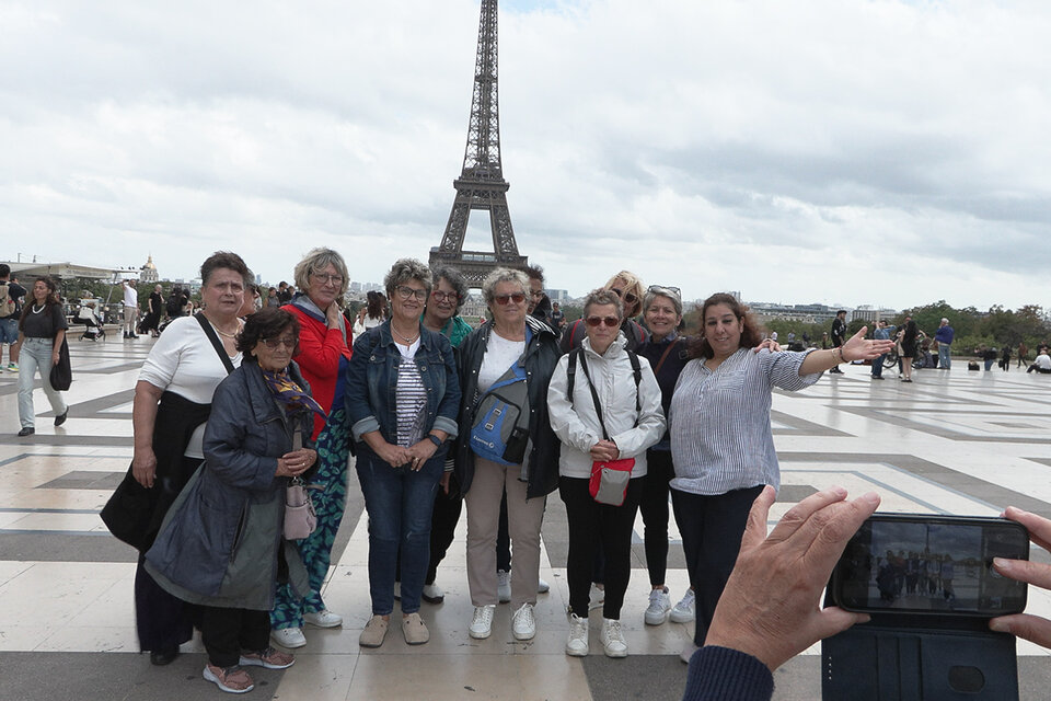 un groupe de vacanciers aidé par le secours catholique devant la tour effeil à paris