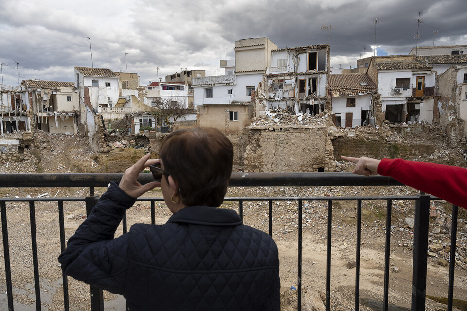 Une habitante observe depuis son balcon les dégâts laissés par les inondations.