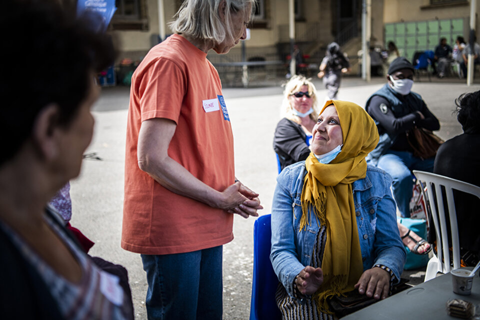 une femme portant le voile et une bénévole discutent
